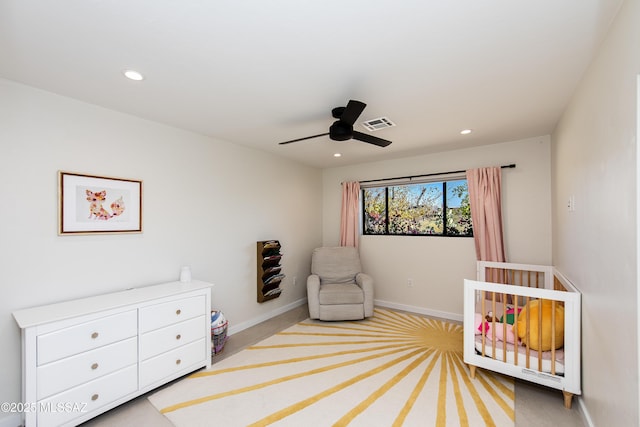 bedroom featuring ceiling fan and a crib