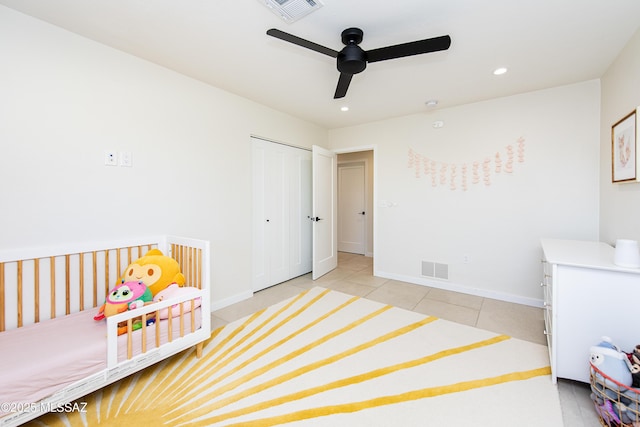 bedroom with a closet, light tile patterned floors, and ceiling fan