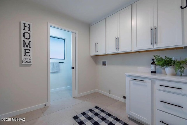 laundry room with washer hookup, cabinets, and light tile patterned flooring