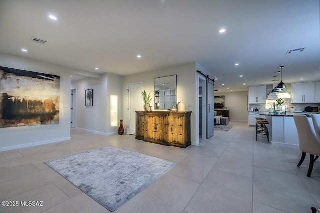 interior space featuring light tile patterned floors and a barn door