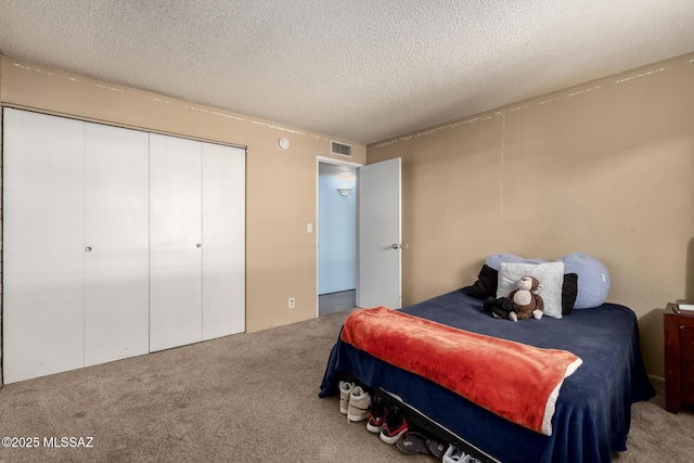 carpeted bedroom featuring a textured ceiling and a closet