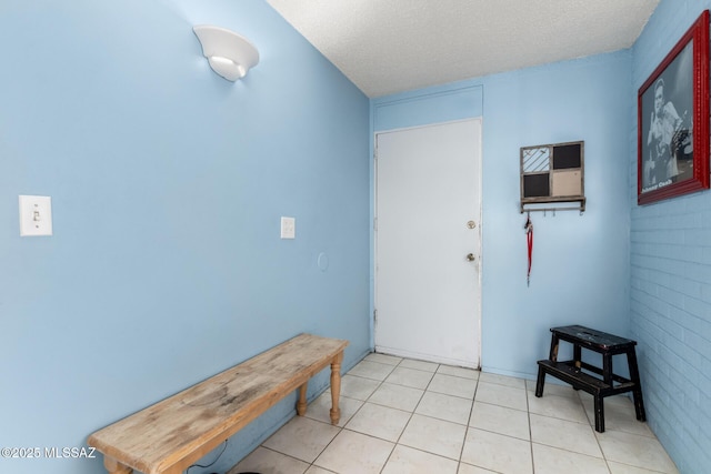 entrance foyer featuring brick wall and a textured ceiling