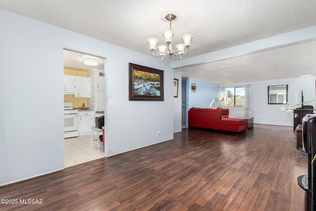 living room featuring a textured ceiling, light hardwood / wood-style floors, and a chandelier