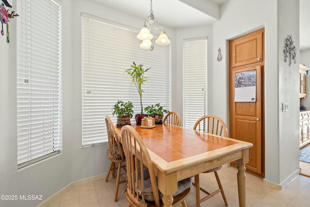 dining room with light tile patterned floors and a notable chandelier