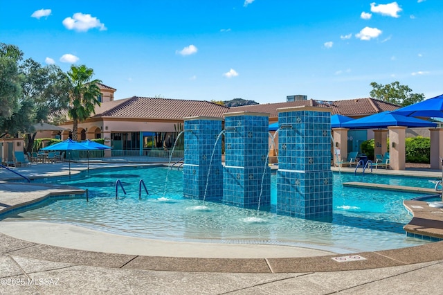 view of swimming pool with pool water feature