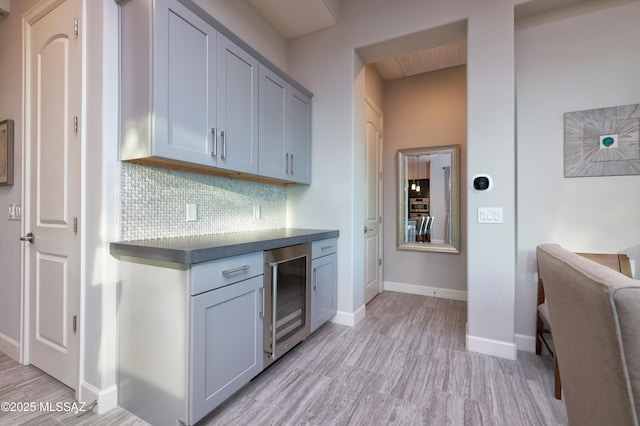 kitchen featuring backsplash, gray cabinetry, and wine cooler