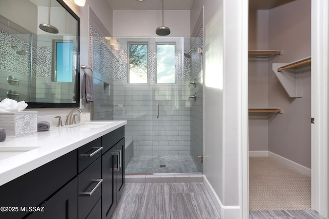 bathroom featuring a shower with shower door and vanity