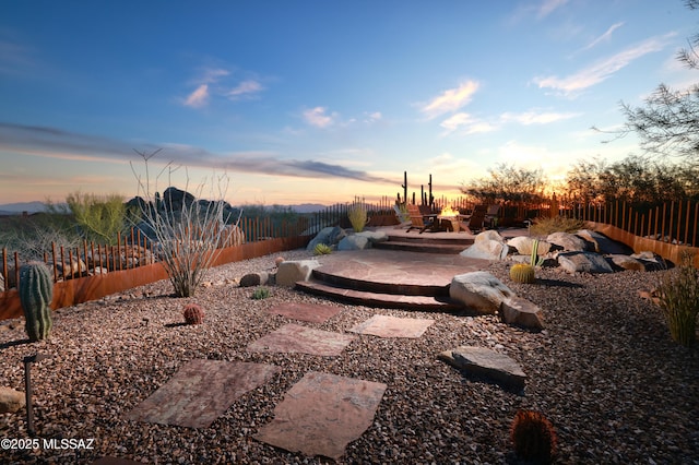 yard at dusk featuring a patio area and a fire pit