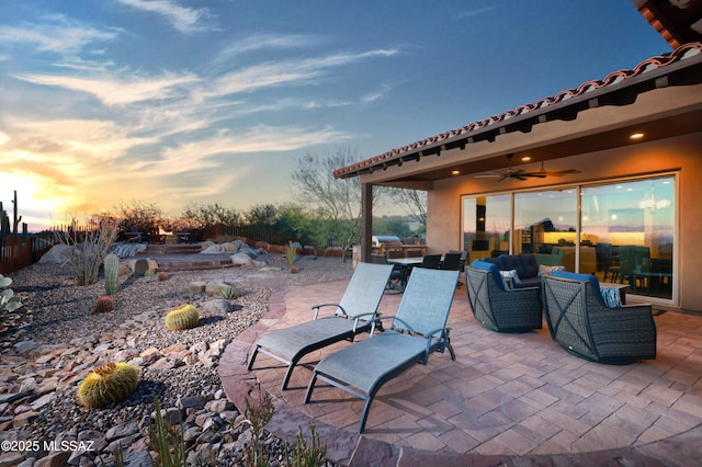 patio terrace at dusk with an outdoor hangout area and ceiling fan