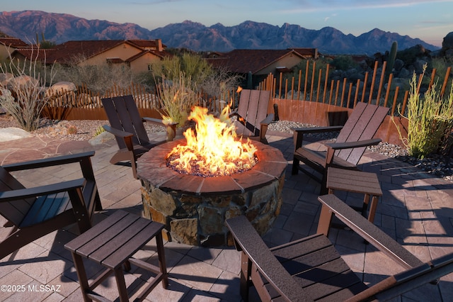 wooden deck with a patio area, a mountain view, and a fire pit