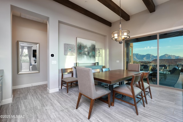 dining room with beam ceiling, an inviting chandelier, and a mountain view