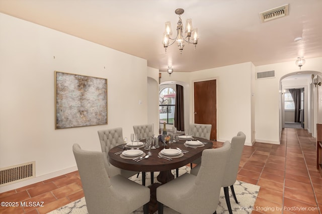 dining space featuring tile patterned flooring and a notable chandelier