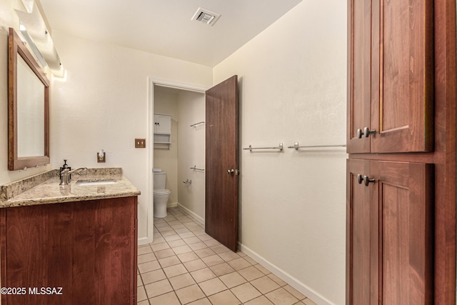 bathroom featuring tile patterned flooring, vanity, and toilet