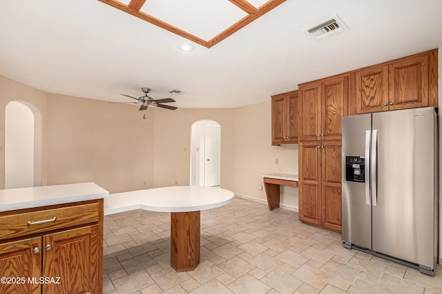 kitchen with a kitchen breakfast bar, ceiling fan, and stainless steel refrigerator with ice dispenser