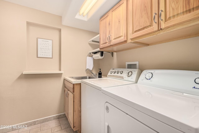 laundry room featuring cabinets, independent washer and dryer, and sink