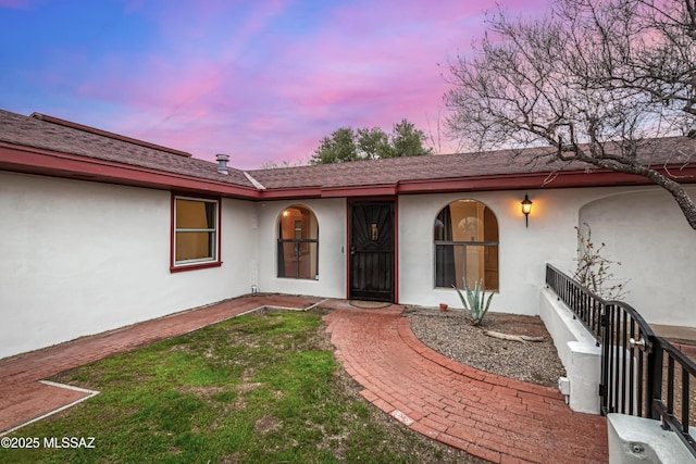 exterior entry at dusk with a lawn