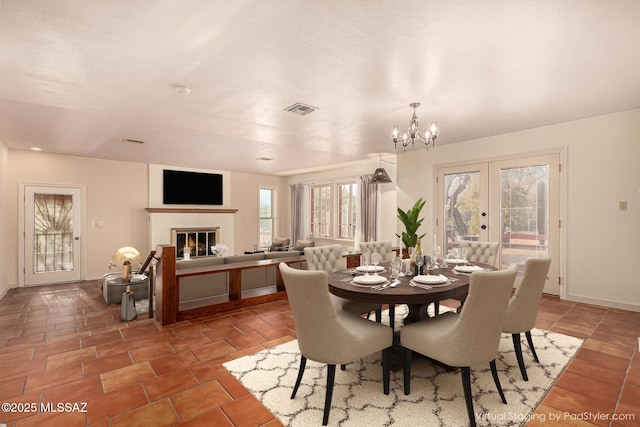 dining area featuring french doors and a chandelier