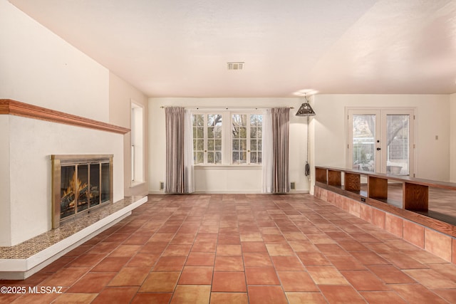 unfurnished living room with a wealth of natural light and tile patterned floors