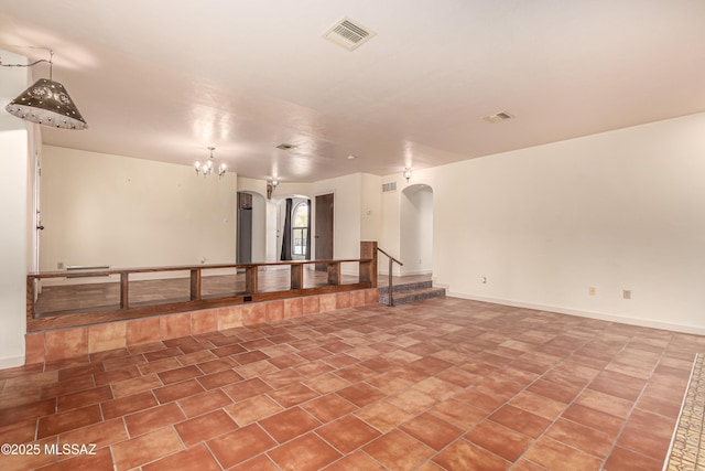 spare room featuring a notable chandelier and tile patterned floors