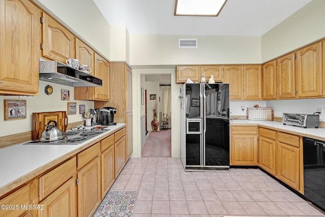 kitchen with light brown cabinets, black appliances, and light tile patterned floors