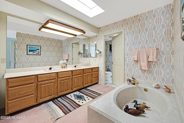 bathroom with toilet, tiled tub, a skylight, and vanity