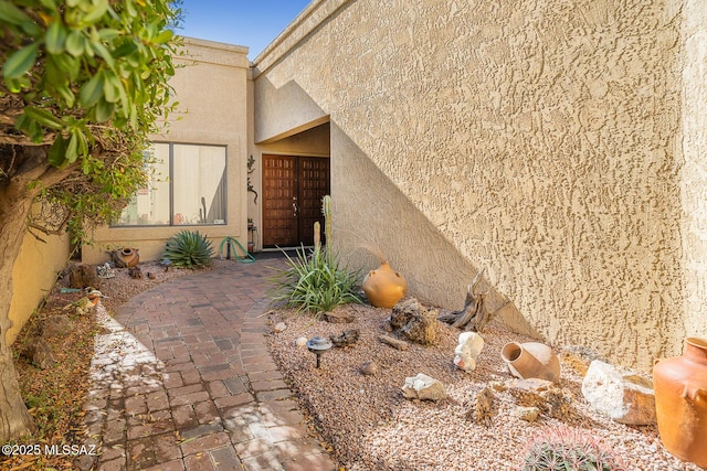 view of exterior entry with a patio