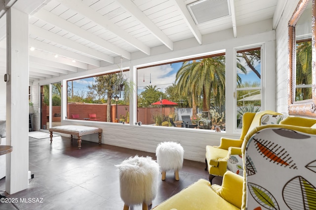 sunroom / solarium with beam ceiling and a healthy amount of sunlight