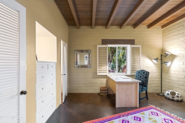 unfurnished office with beamed ceiling and brick wall