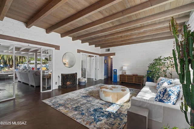 living room with beam ceiling, a fireplace, wooden ceiling, and brick wall