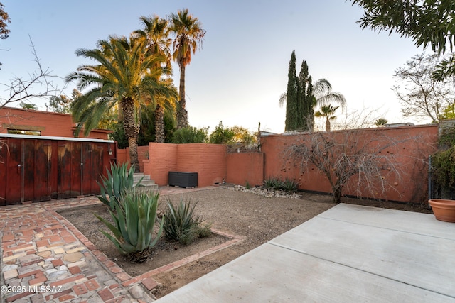 yard at dusk featuring a patio