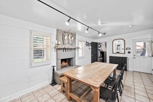 tiled dining room with a brick fireplace