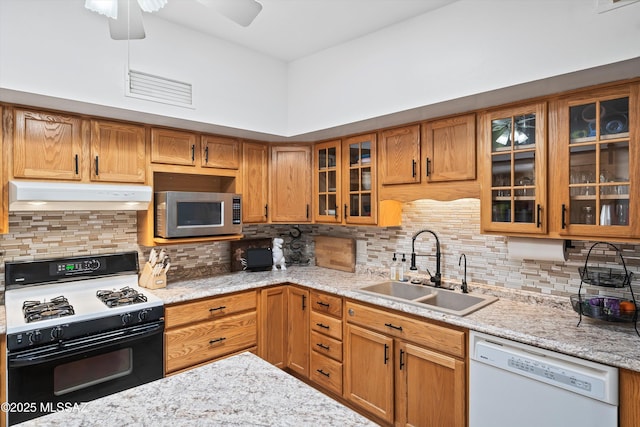 kitchen with white dishwasher, sink, gas range oven, and tasteful backsplash