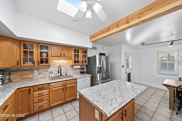 kitchen with stainless steel fridge with ice dispenser, a skylight, dishwasher, a kitchen island, and sink