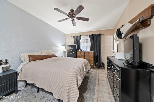 tiled bedroom featuring vaulted ceiling, ceiling fan, and brick wall