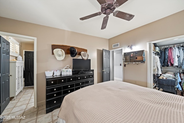 bedroom featuring ceiling fan, light tile patterned floors, and a closet