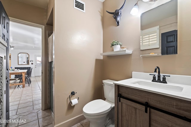 bathroom featuring toilet, tile patterned flooring, and vanity