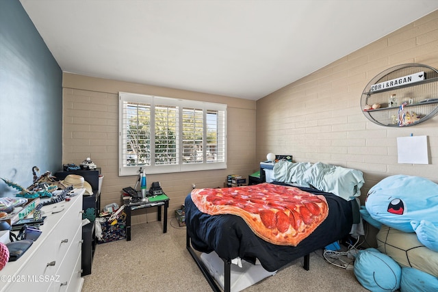 bedroom featuring light carpet, brick wall, and lofted ceiling