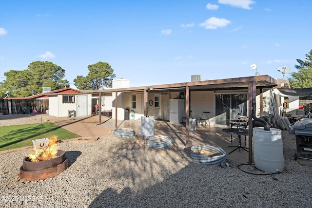 rear view of house with an outdoor fire pit and an outdoor structure