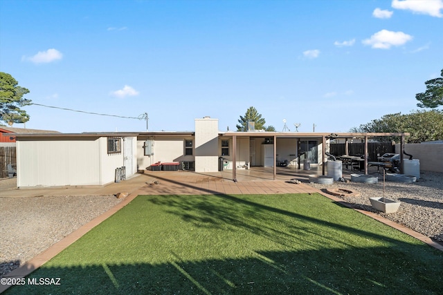 back of house featuring a lawn and a patio