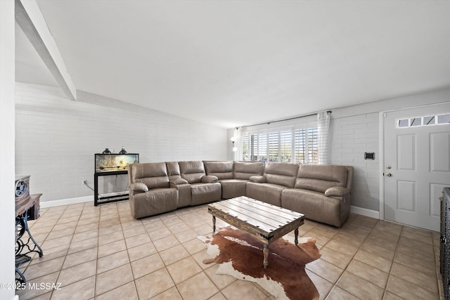 living room with light tile patterned flooring and brick wall