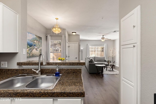 kitchen featuring sink, white cabinetry, dark hardwood / wood-style floors, and pendant lighting