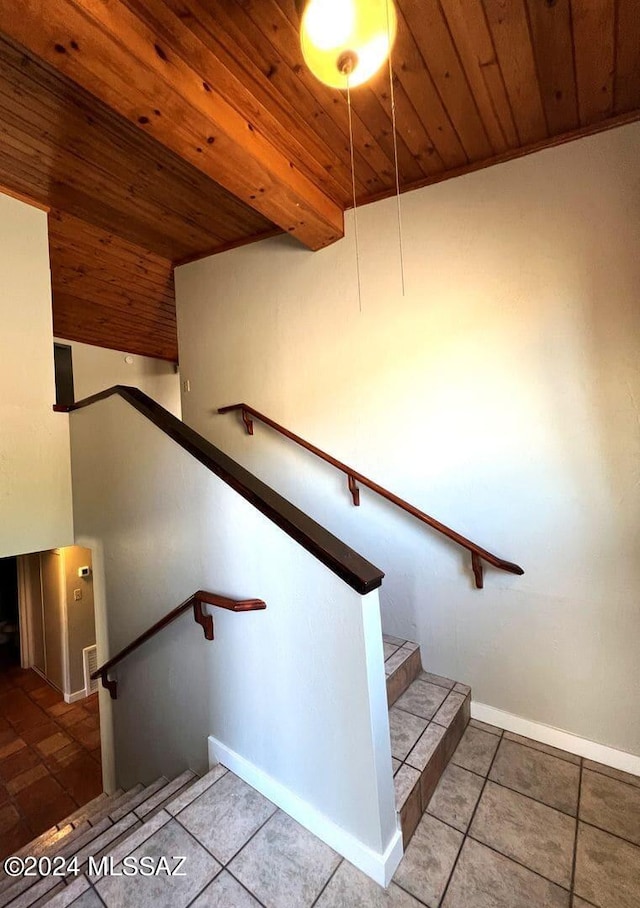 stairway with tile patterned floors and wood ceiling