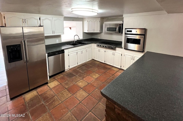 kitchen featuring appliances with stainless steel finishes, white cabinetry, and sink