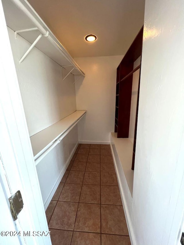 spacious closet with dark tile patterned flooring