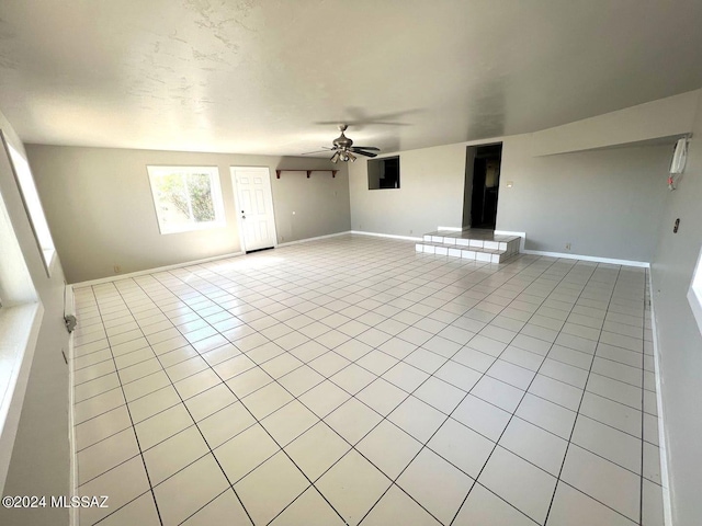 unfurnished living room featuring light tile patterned flooring and ceiling fan