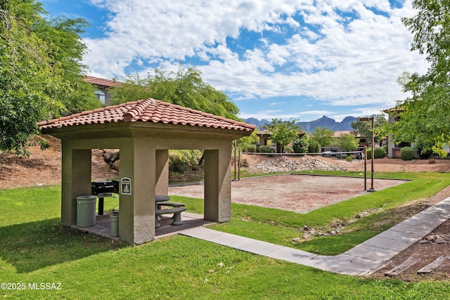 view of property's community with a mountain view, a gazebo, volleyball court, and a lawn