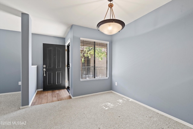 foyer entrance featuring light carpet