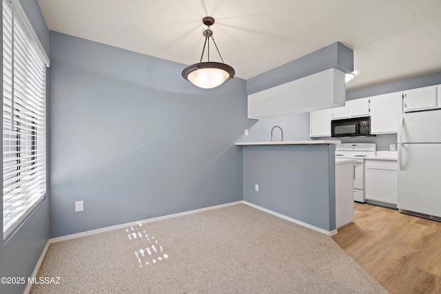 kitchen featuring light hardwood / wood-style floors, kitchen peninsula, white appliances, hanging light fixtures, and white cabinets