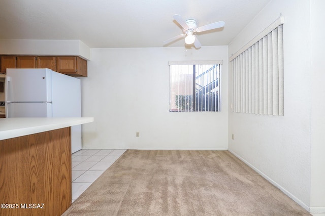 kitchen featuring white refrigerator, light tile patterned floors, and ceiling fan