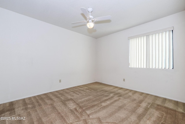 carpeted spare room featuring ceiling fan